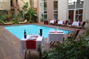 卡萨布兰卡卡萨布兰卡套房Spa酒店的一间带2张桌子和游泳池的餐厅