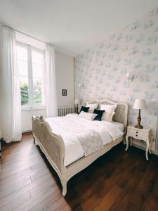 Caux-et-SauzensKarma Chateau de Samary的一间卧室配有一张带蓝色花卉壁纸的大床
