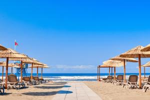 乌尔齐尼Azul Beach Resort Montenegro by Karisma - All Inclusive的海滩上设有椅子和遮阳伞,还有大海