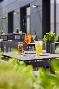 爱尔福特LÉGÈRE HOTEL Erfurt的一张桌子,上面放着两杯饮料,上面放着植物