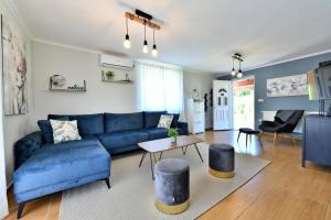 拉科维察Apartments Green Park Plitvice的客厅配有蓝色的沙发和桌子