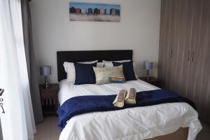 博克斯堡OR Tambo Self Catering Apartments, The Willows的一间卧室,床上有两双鞋