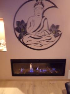 洛翁普拉日chambre avec spa privatif的一张佛陀坐在一个带壁炉的房间里的照片