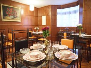 内罗毕The Drexel House Kenya的用餐室配有带盘子和玻璃杯的桌子