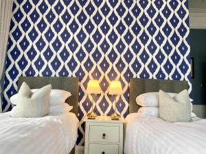 奥本Barriemore Oban的配有两张蓝色和白色壁纸的床铺