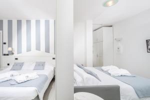 利尼亚诺萨比亚多罗贝拉维斯塔酒店的白色客房的两张床,配有镜子