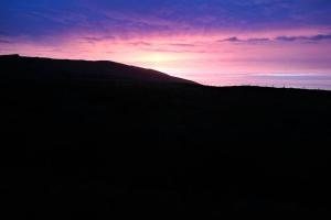 波特马吉Skellig View Bluebell Rose & The Kerry Cliffs的山丘上的日落,太阳落在山后