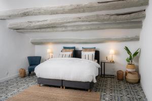 奥拉尔盖Ecole Olargues - Teritoria的一间卧室配有白色的床和2把蓝色的椅子