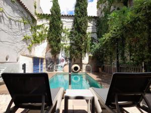 孔苏埃格拉昔日生活乡村酒店的一个带两把椅子的游泳池和一个喷泉