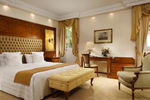 莫尔科泰Swiss Diamond Hotel & Spa的一间卧室配有一张大床和一张桌子及椅子