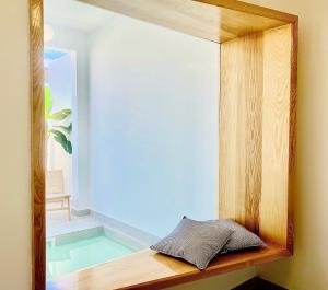 宏达海滩Canaryislandshost l Boya Suites的一面镜子坐在游泳池旁的木架上