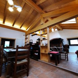 CasargoLa Casa nel Bosco - Your Mountain Holiday的一间拥有木制天花板和桌椅的用餐室