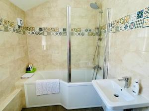 朴次茅斯Clive Crest house的带浴缸、水槽和淋浴的浴室