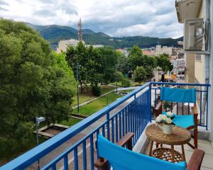 克桑西Hospitable appartment in the central park, Xanthi的阳台配有蓝色椅子和一张桌子,享有美景。