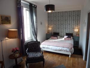 蓬托尔松贝尔斯德迈庄园酒店的卧室配有床、椅子和窗户。