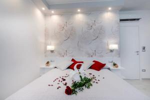 马奥莱Profumo di Mare Offre Parcheggio Gratuito的一张带红色枕头和鲜花的白色床