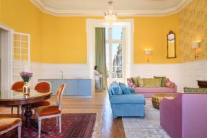 里斯本Residentas Arco do Bandeira的客厅设有黄色的墙壁和桌椅