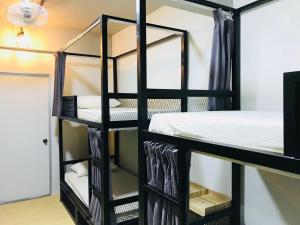 雪邦The Good Travelers Hostel - KL Airport的一间房间,配有一张黑色双层床