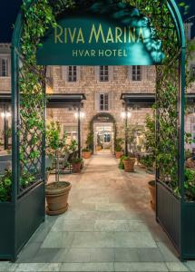 赫瓦尔Riva Marina Hvar Hotel的植物盆栽的酒店入口