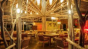 博拉科特Roka Resort的一间带桌椅和大型天花板的餐厅
