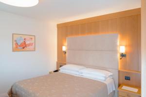 坎皮泰洛迪法萨拉狄那酒店的一间卧室配有一张带两个白色枕头的床
