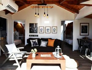Countryside Loft - Inachos的客厅配有黑色沙发和桌子
