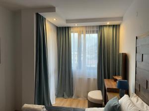 切佩拉雷Апартамент Стил的一间卧室设有窗户,配有绿色窗帘