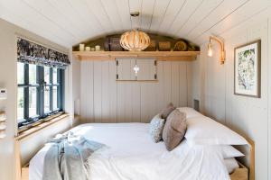 朗塞斯顿Boutique Cornish Shepherd's Hut with Hot Tub的卧室配有白色的床