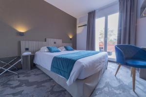 乐巴凯尔斯The Originals City, Relax'Otel & Spa, Le Barcarès的一间卧室配有一张大床和一张蓝色椅子