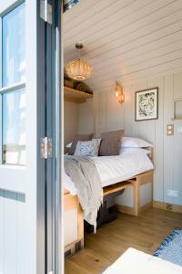 朗塞斯顿Boutique Cornish Shepherd's Hut with Hot Tub的卧室配有一张床