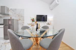 尼亚卢卡Villa Green Bay Apartments的一间设有玻璃桌和椅子的用餐室