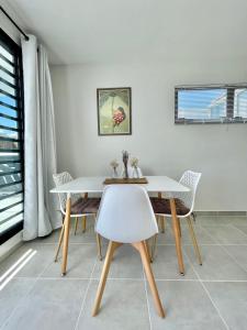 帕皮提Mereani flat brand new condo in the center of Papeete的一间配备有白色桌椅的用餐室