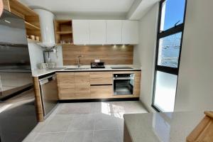 帕皮提Mereani flat brand new condo in the center of Papeete的厨房配有白色橱柜和水槽