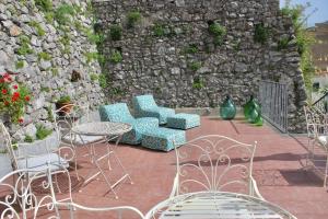 斯卡拉马鲁旅馆的一个带桌椅的庭院和石墙