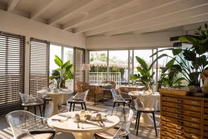 利多迪耶索罗德尔纳西奥尼酒店的餐厅设有桌椅和窗户。