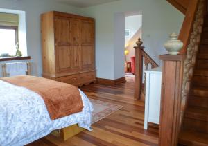 KinlossThe Tower, Moray Firth Holiday Home的一间卧室配有一张床和一个木制橱柜