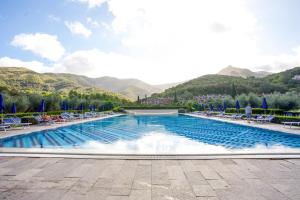 SantʼAnnaBilocale Sant'Anna Vicolo del Mughetto的一个带椅子的游泳池,背景是山脉