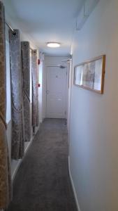 托基Barclay Court Guest House的走廊上设有白色门,配有窗帘和照片