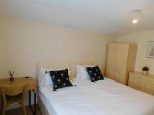 伦敦Entire 4 bedroom Terrace house in London的卧室配有白色的床和木桌
