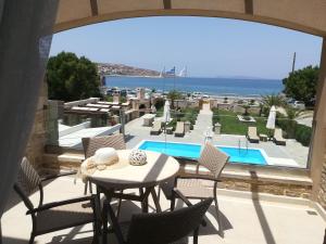锡蒂亚Blue Horizon Villa & Suites的一个带桌椅的庭院和一个游泳池