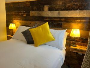 伦敦The Brookmill的一间卧室配有一张带枕头的床和两盏灯。