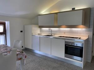 CaresCasa vacanze nonna Orsola的厨房配有白色橱柜和炉灶烤箱。