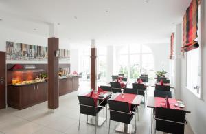 文斯托夫伯格曼斯霍夫酒店的一间设有红色桌椅的餐厅以及一间自助餐