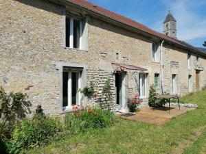 CommesMaison renovee en pierres séjour spacieux avec jardin et terrasse aménagée près Omaha beach & Bayeux à 5mn de la mer tous commerces的石头建筑,外面有桌子