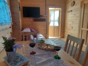 BachowiceDomek Kalilla的一张桌子,上面放着两杯葡萄酒和一盘食物