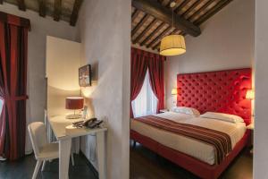 费拉拉那锡那里酒店的一间卧室配有红色床头板、一张桌子和一张床