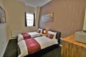 格洛斯特格洛斯特中央酒店的酒店客房设有两张床和电视。