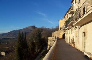 福萨托-迪维科Appartamento nel Castello presso Gubbio的一条街道,有一座建筑,有一座山,背景