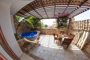 兰佩杜萨Cupola Bianca Resort的庭院设有热水浴池、桌子和椅子。