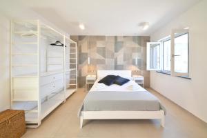 伊斯基亚Fortino Uno的卧室配有白色的床和架子